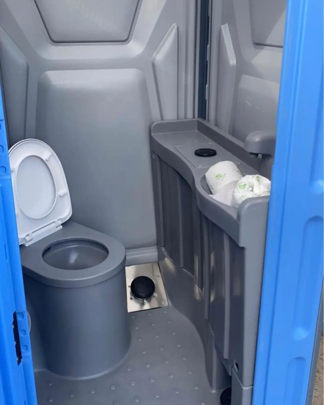 Deluxe porta potty interior with toilet, counter and paper dispensers