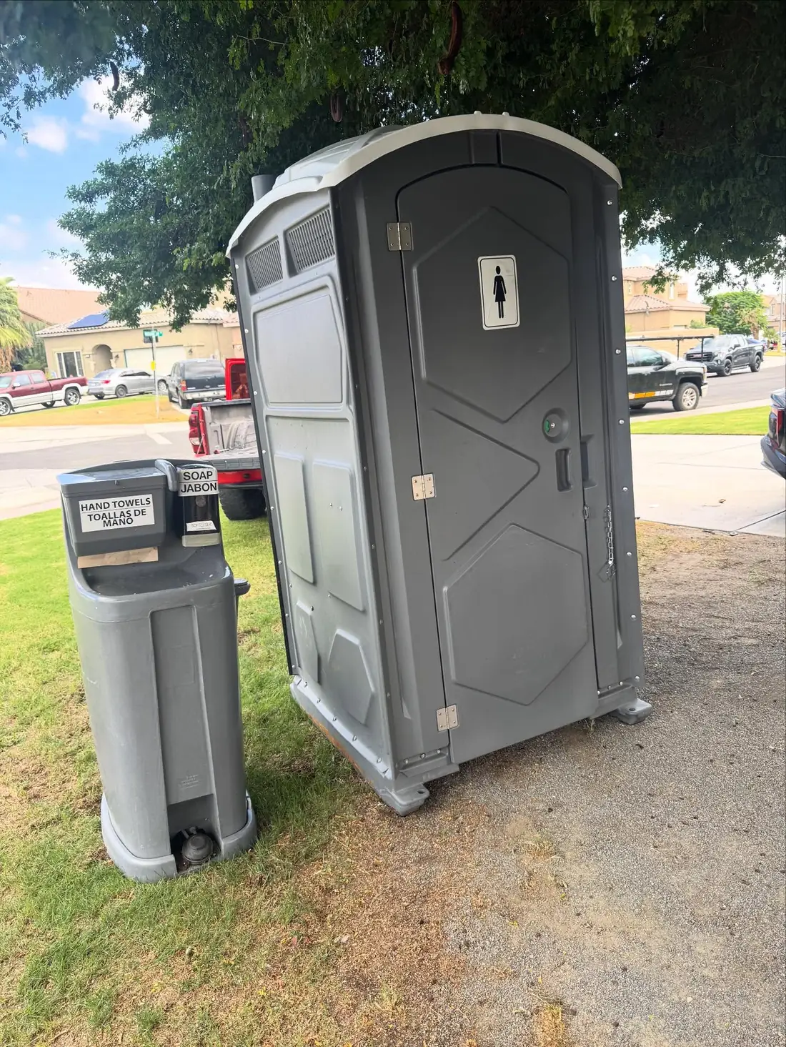 gray standard porta potty with hand wash station