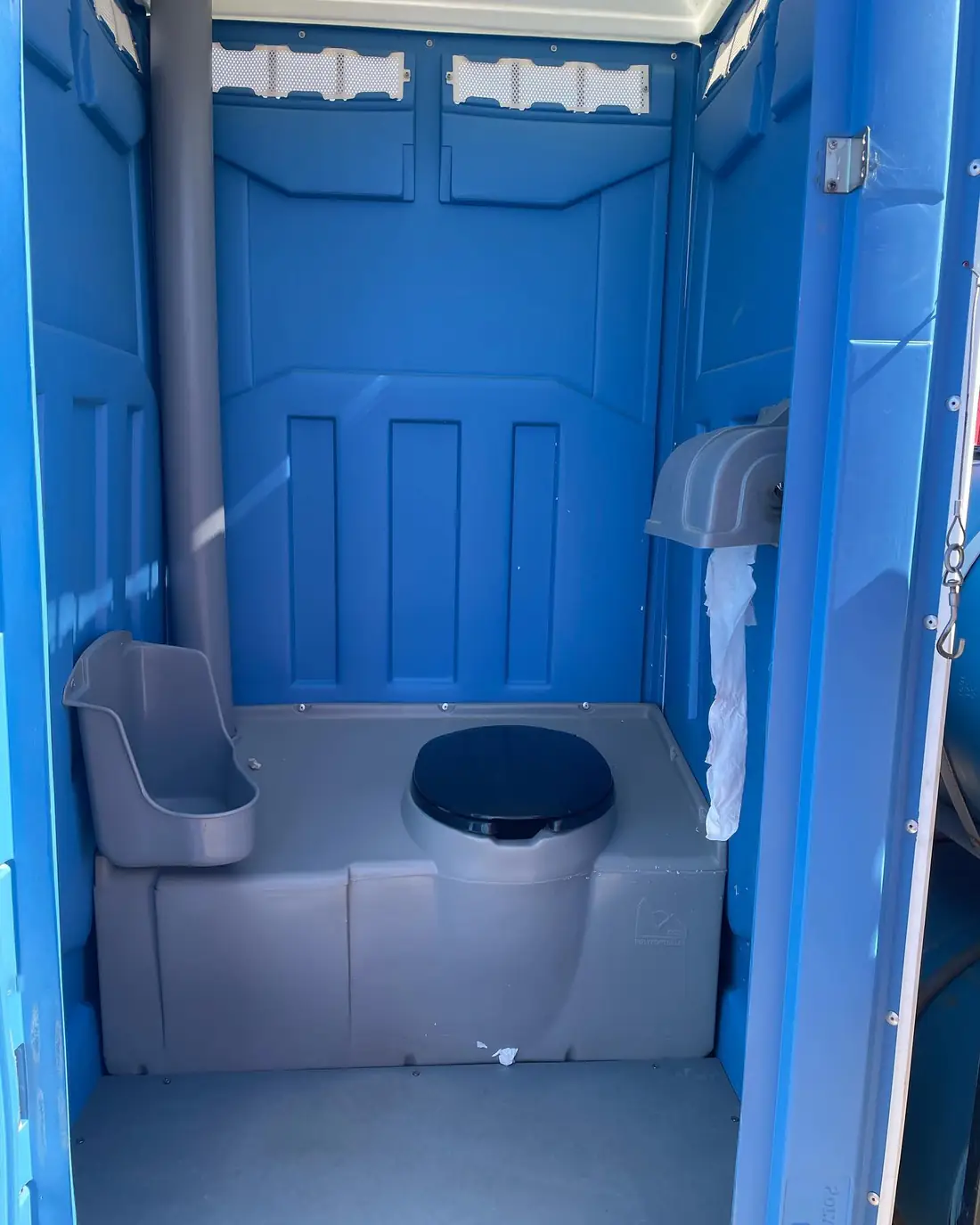 Porta potty interior with paper dispenser and seat